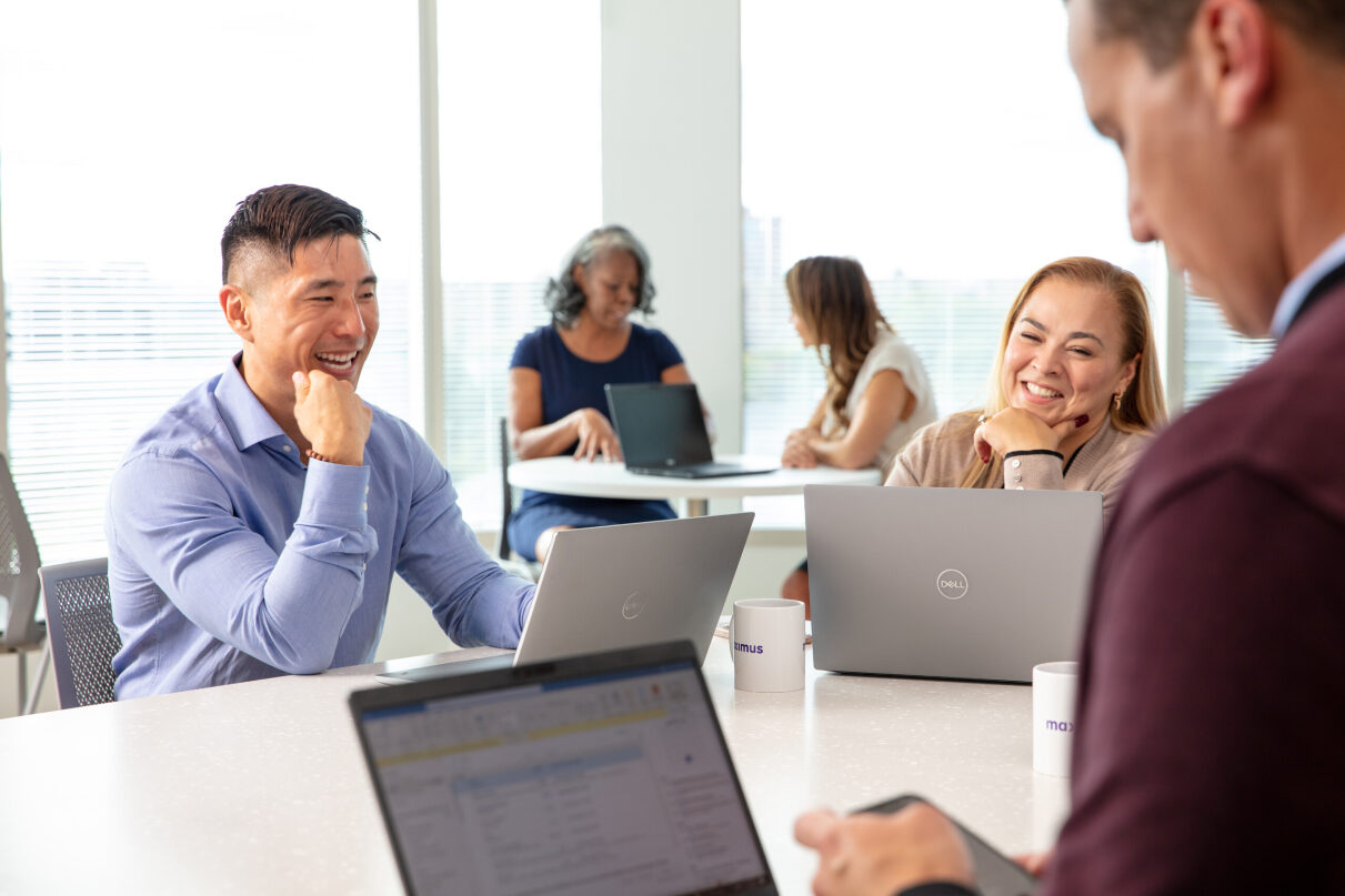 Group of employees smiling while talking in a group