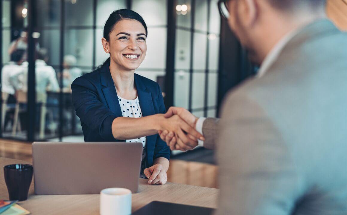 Woman shaking an interviewers hand.
