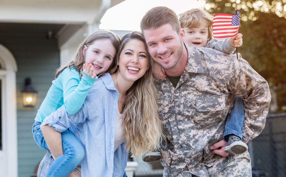 Excited soldier happily  reunited with his young family.