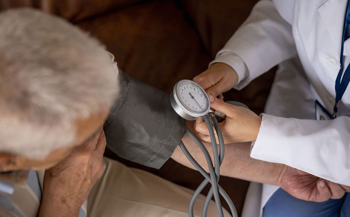 Medical provider measuring blood pressure of an elderly patient