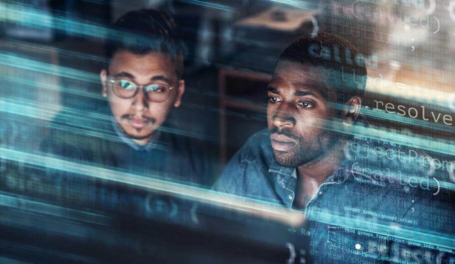 men working looking at computer screen