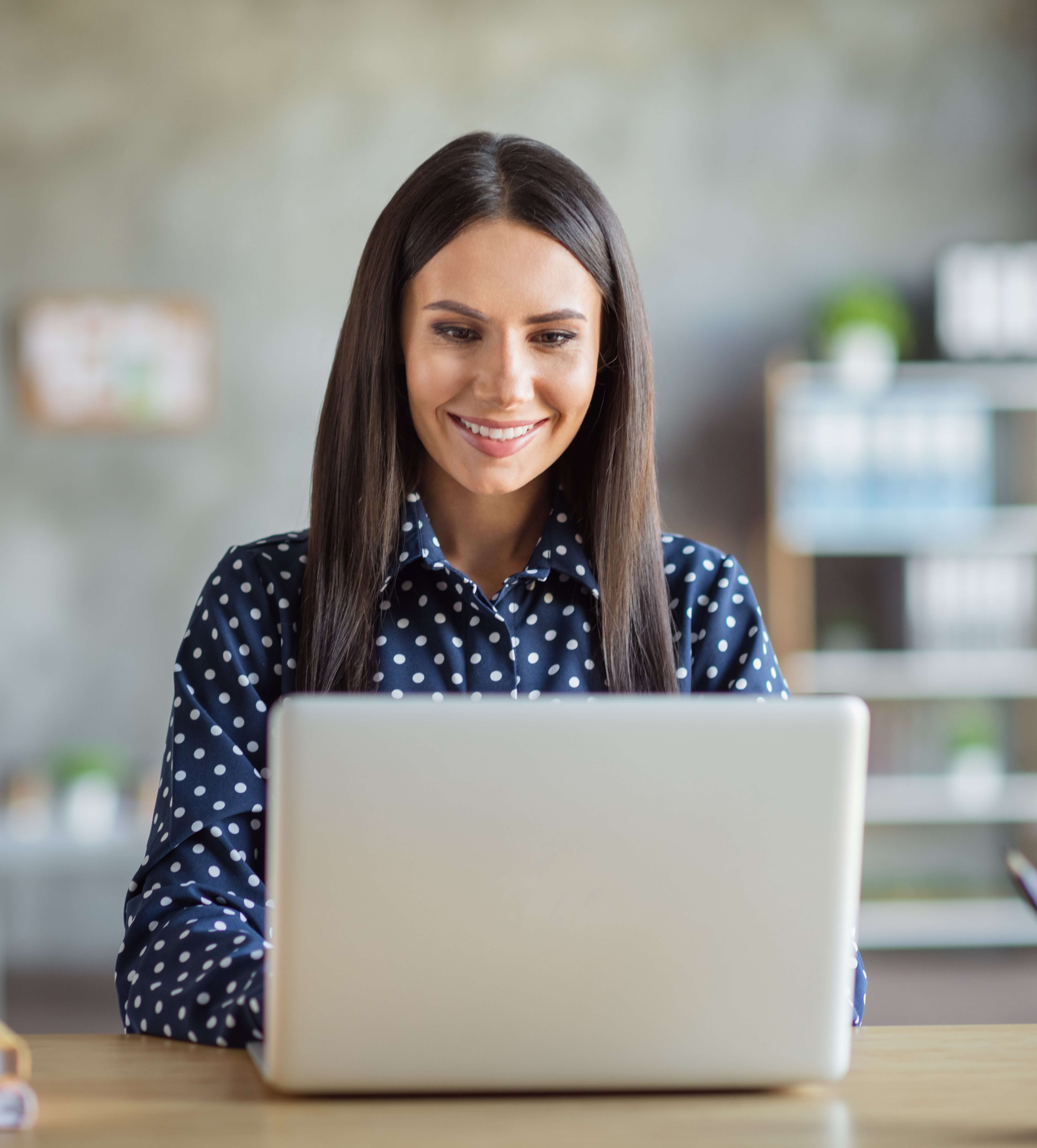 young woman smiling working on laptop