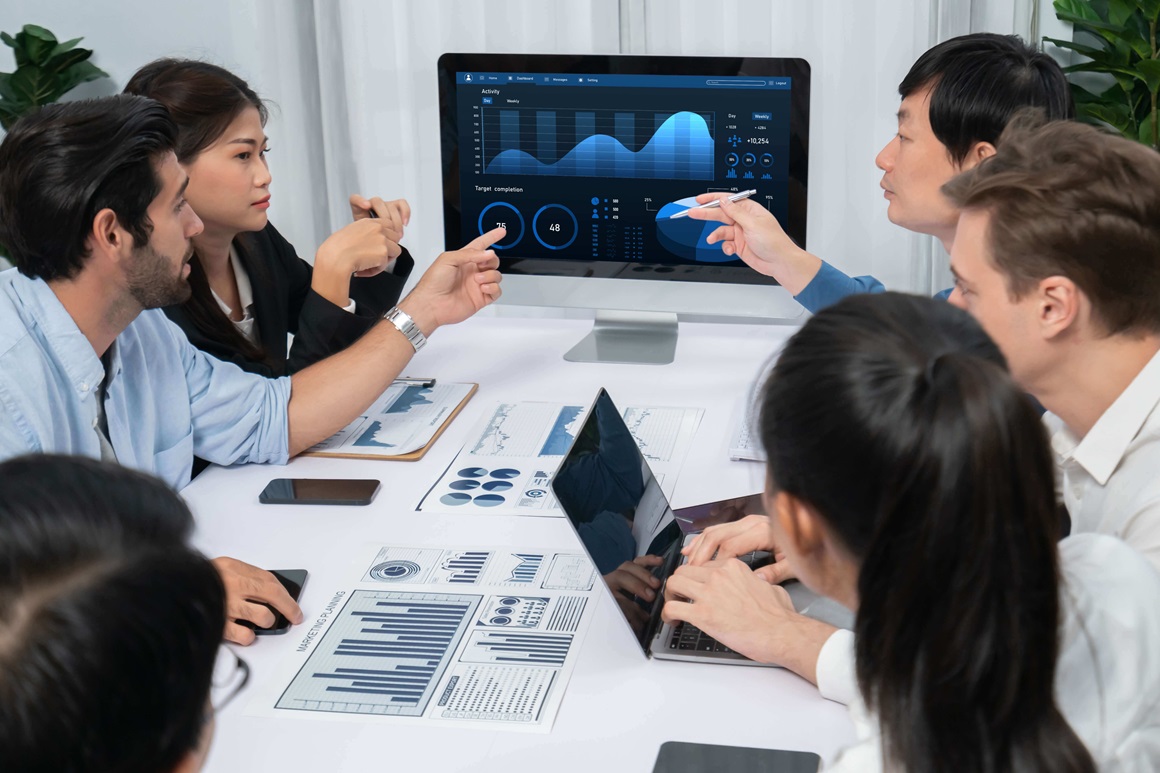 Analyst team analyzing data at table to inform service delivery