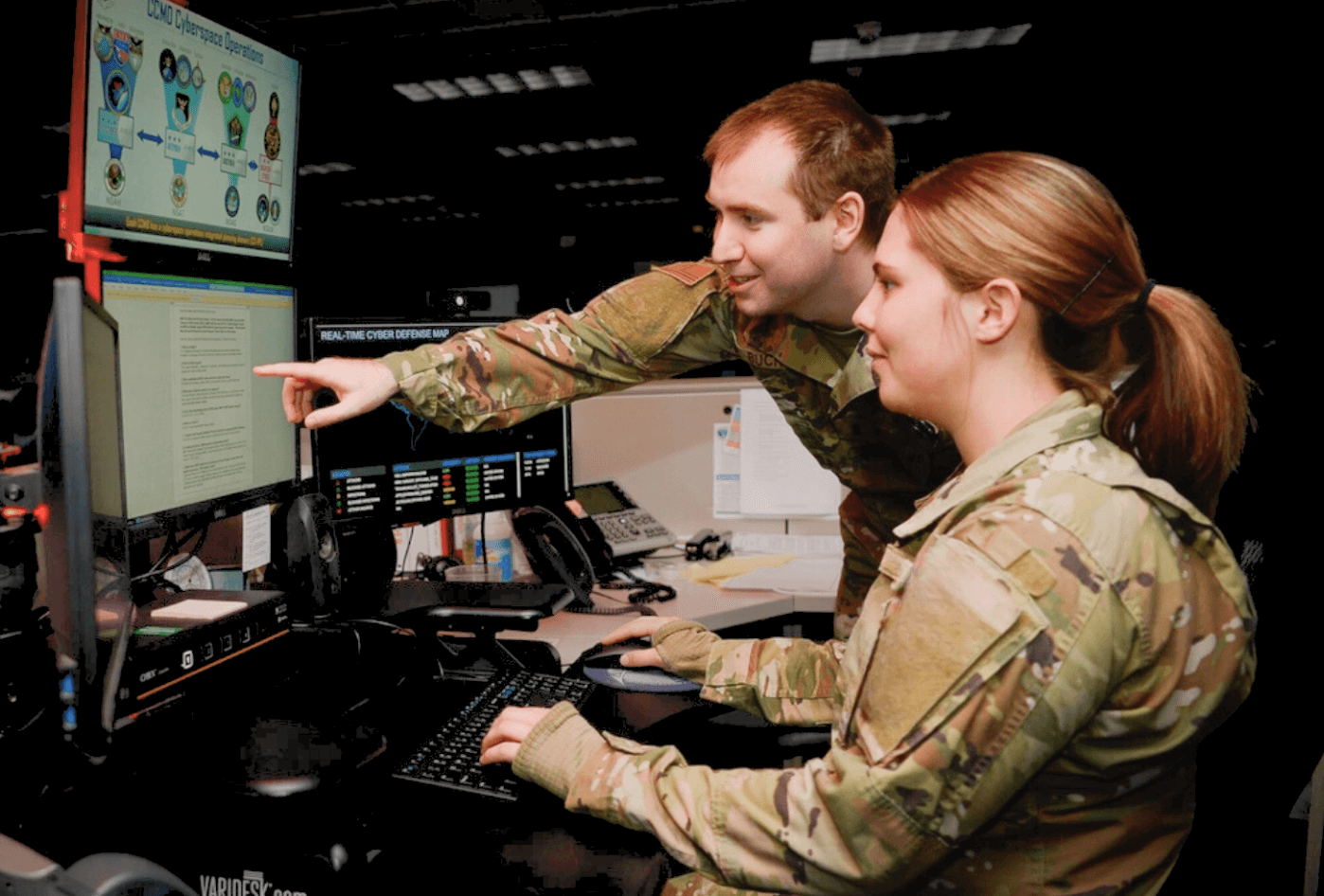 Two military members looking at a computer screen together