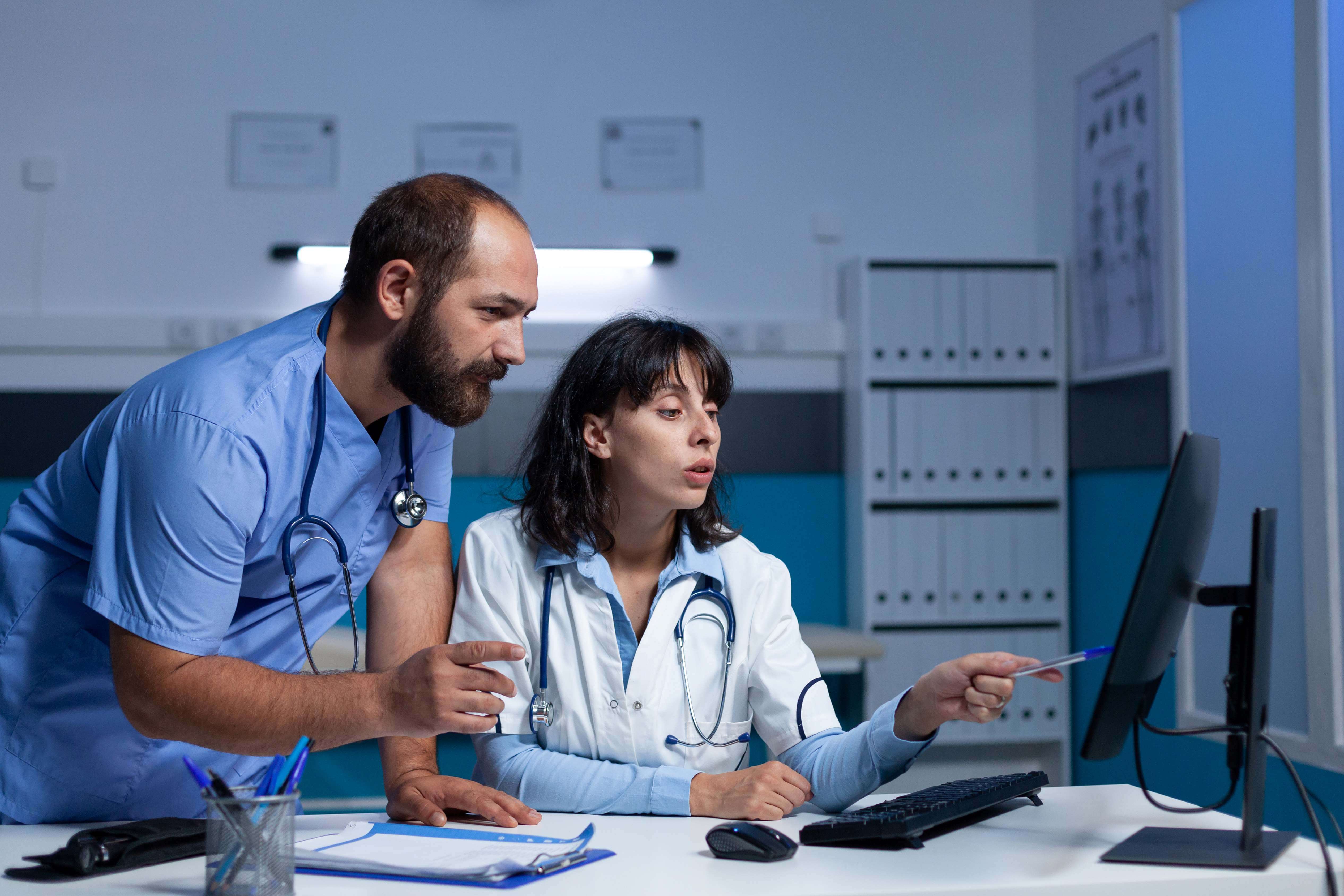 Doctor and nurse pointing at computer for patient information