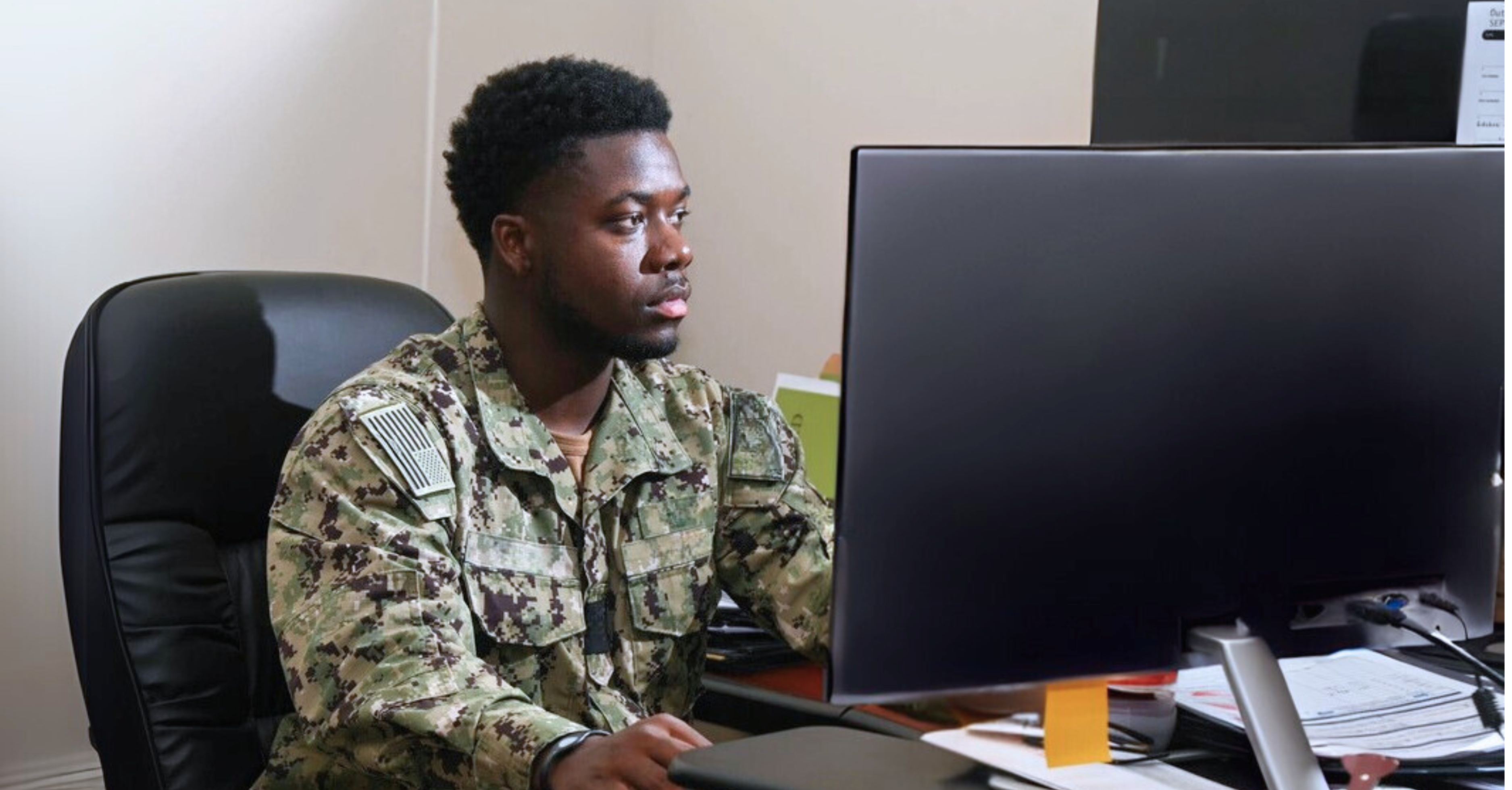 Navy serviceman sitting at a computer 