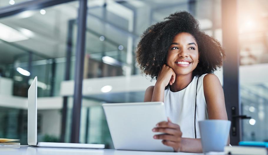 Female job seeker smiles and looks off to the side while holding a tablet in one hand.