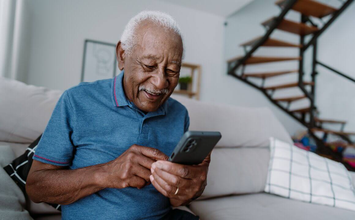 Elderly man using smartphone at home