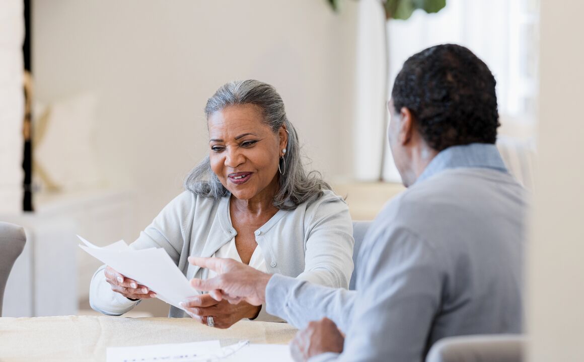 An elderly black woman being consulted.