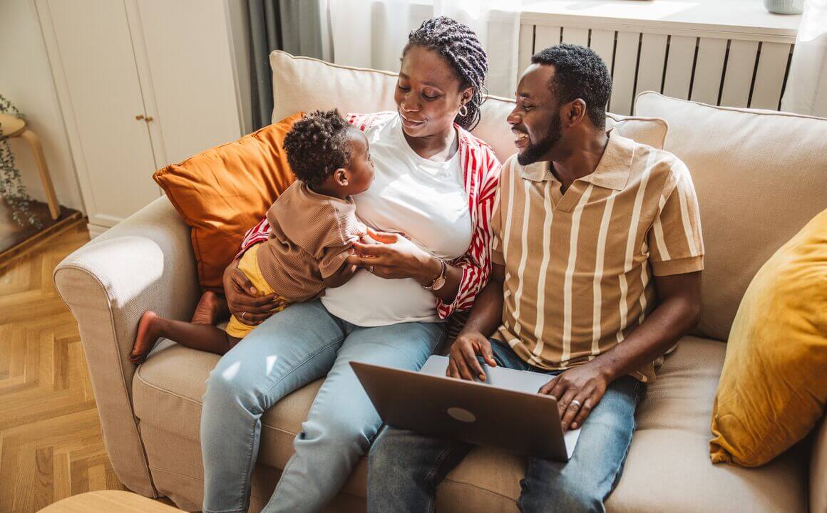 A happy young family at home selecting the best health plans and doctors for their family.