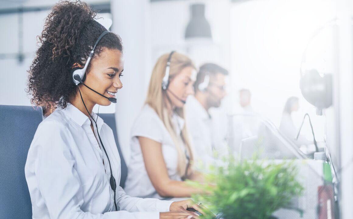 Customer contact center agents wearing headsets help Vermont residents enroll in health insurance coverage over the phone.