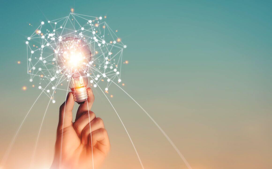 Hand holding brain digital network and abstract science light bulb inside on networking connection on sky background.