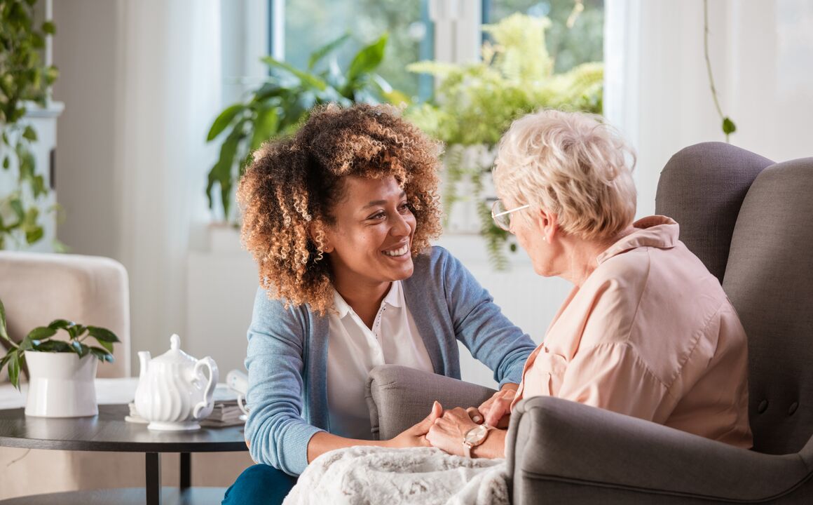 Female clinical professional conducts a level of care determination assessment for an older woman in her home.