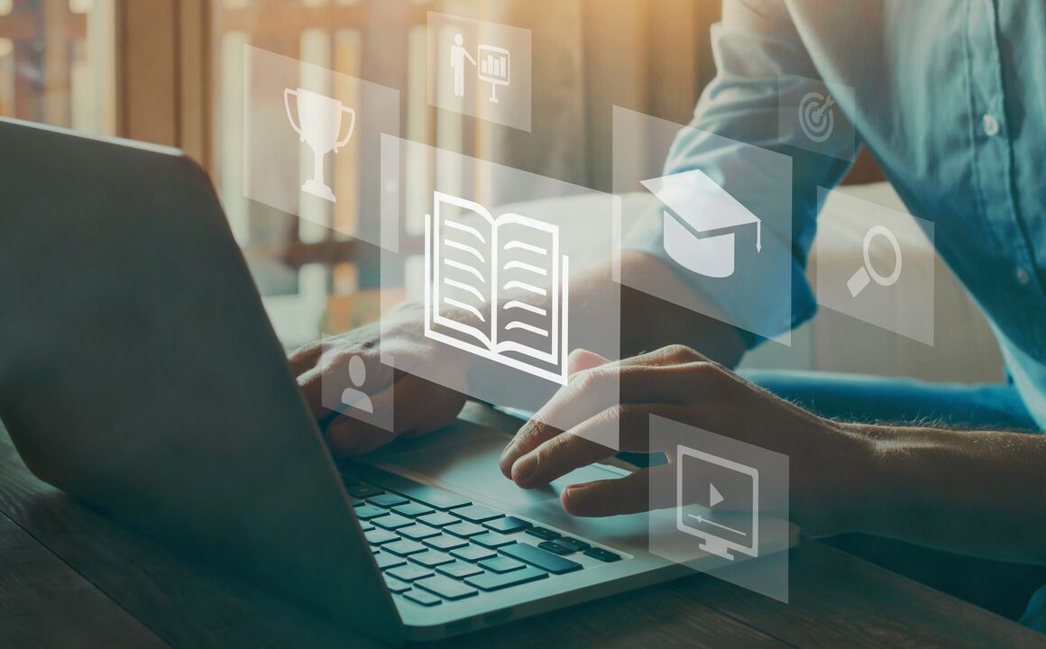 Close up of hands typing on laptop with digital icons showing growth opportunities and goals