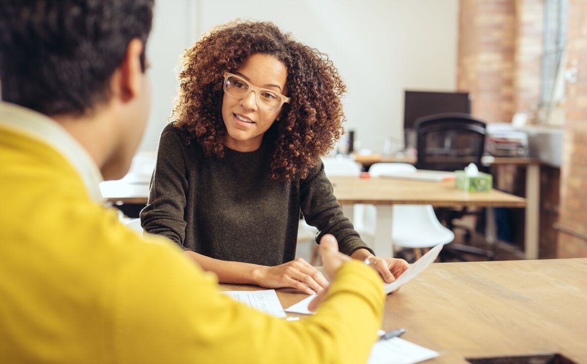 Female case manager listens intently to a male SNAP recipient and job seeker 