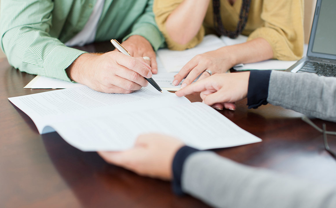 Image of hands signing a contract