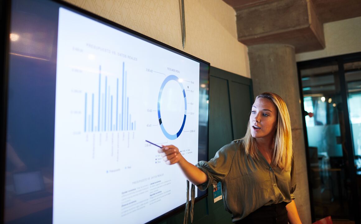 Image of woman presenting data graphs on a screen