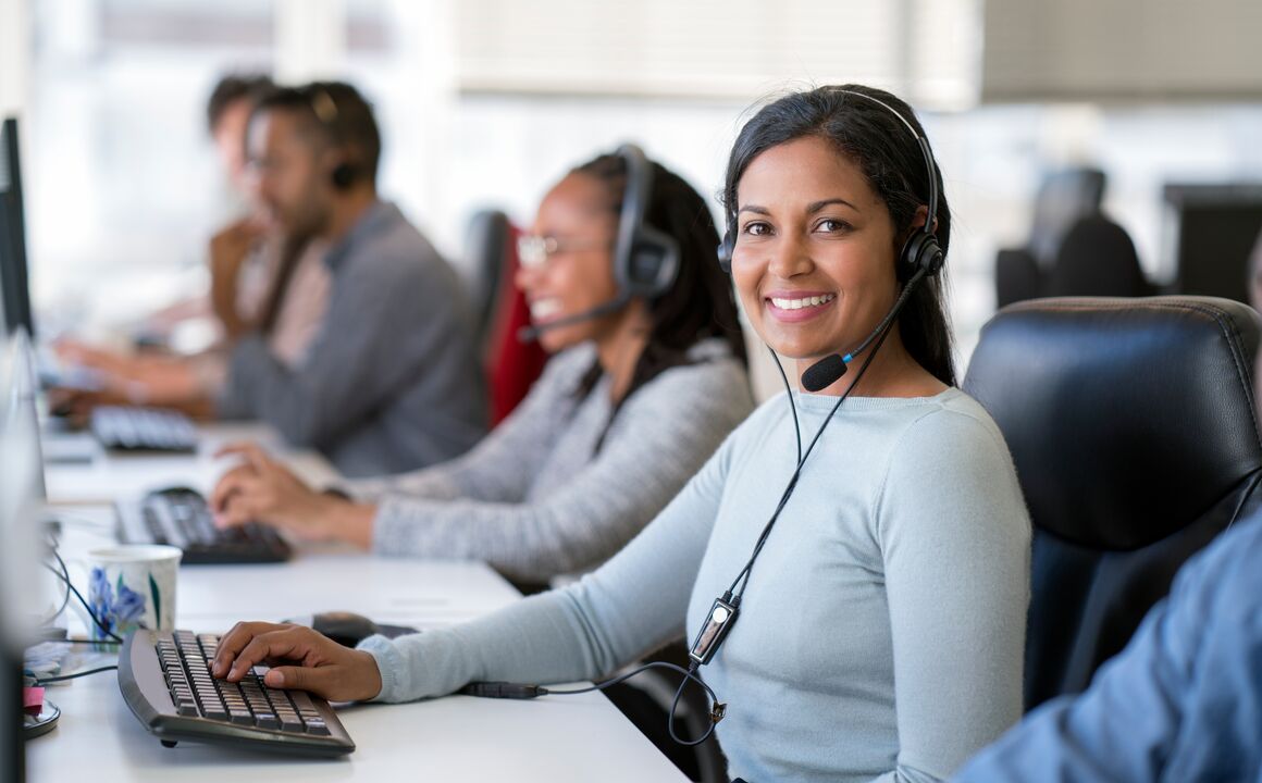 Image of a customer service representative smiling while on a call with a customer