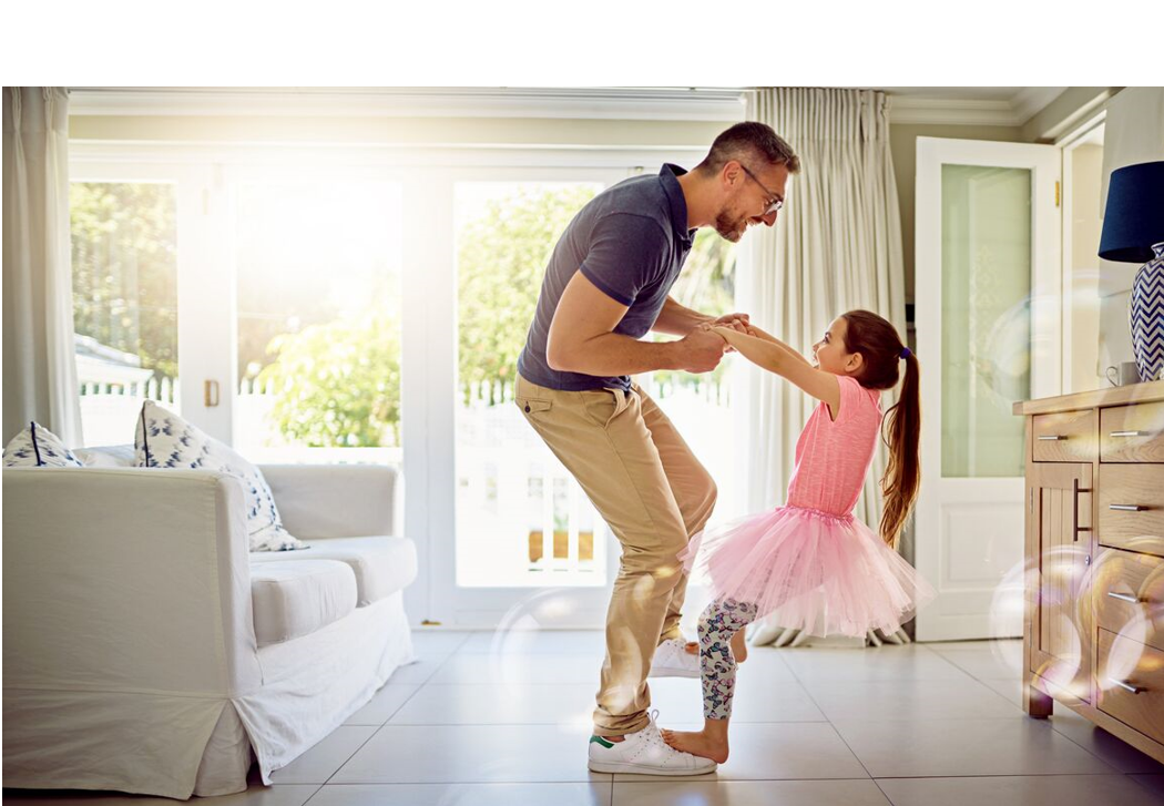 Image of a father and daughter dancing in the living room