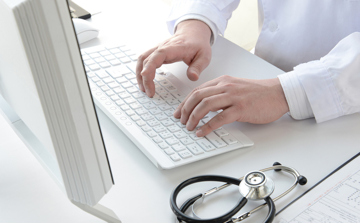 Image of a medical professional typing on a keyboard
