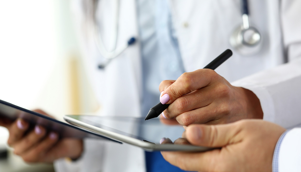 Image of a doctor writing on a tablet screen