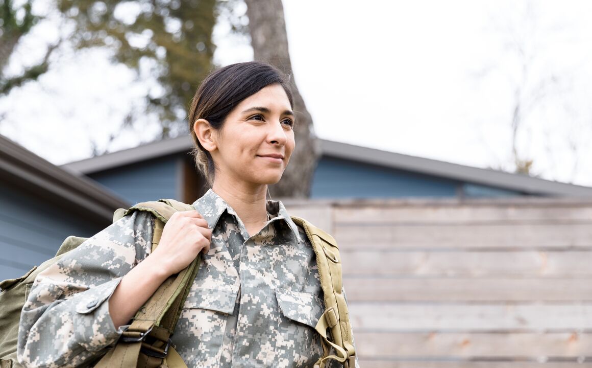 Image of a woman in uniform smiling outside