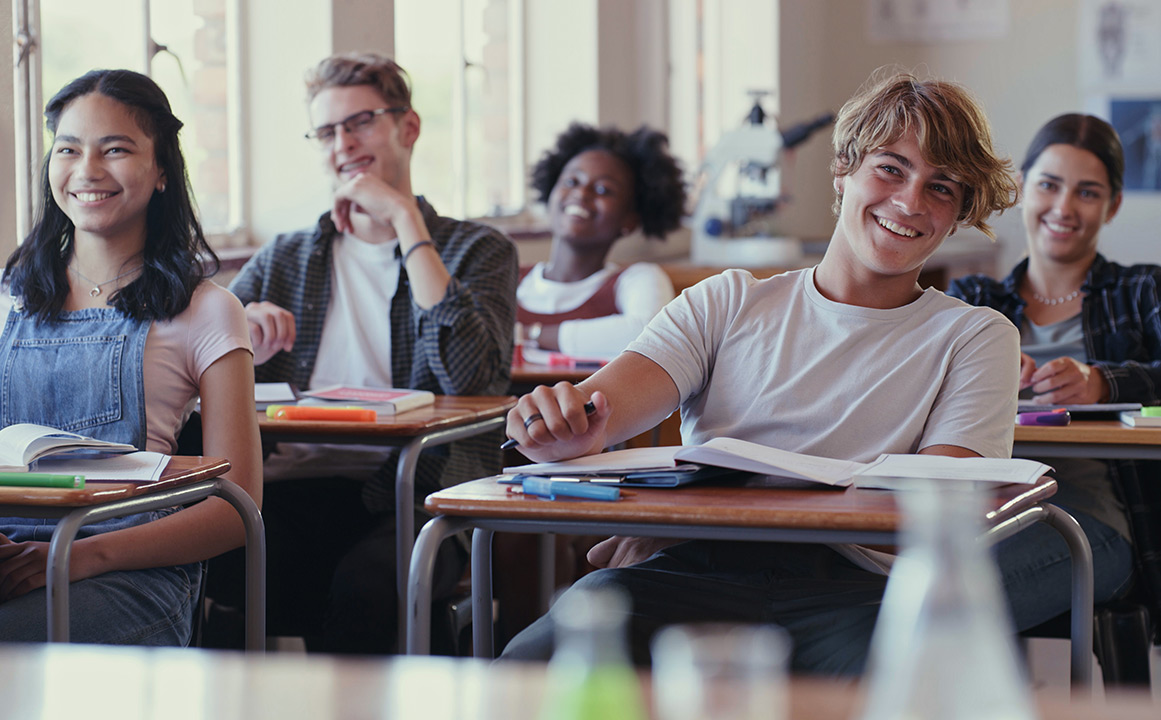 Image of students smiling in a classroom