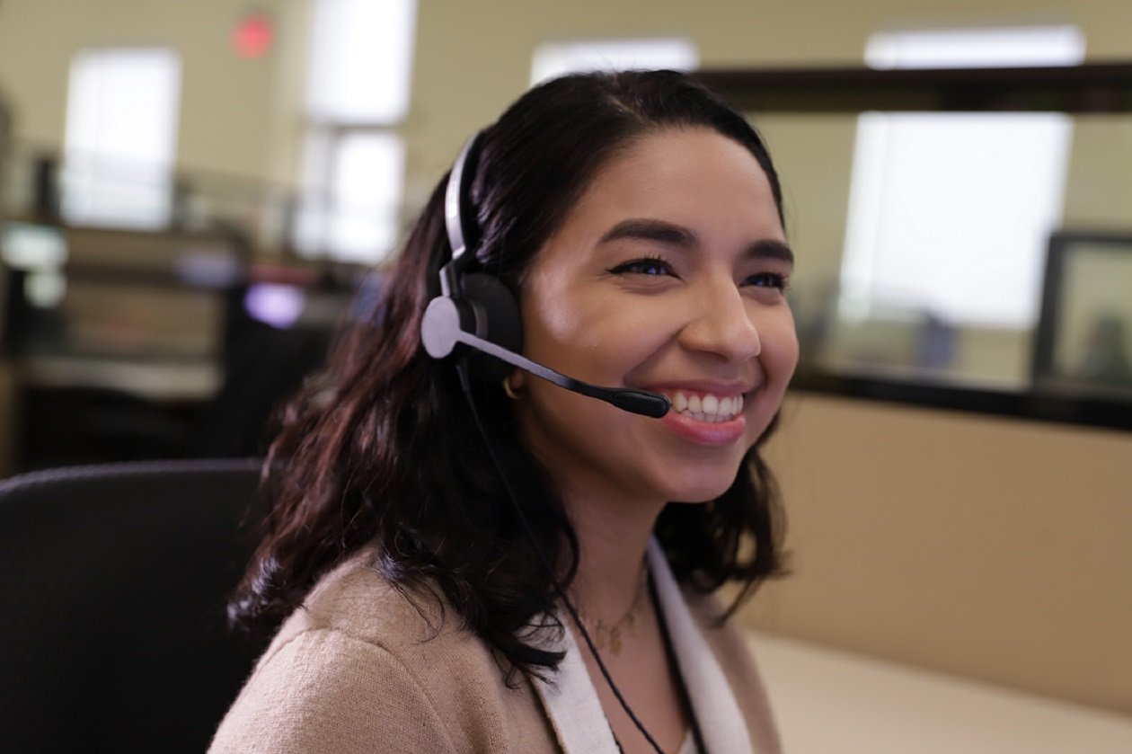 Image of a call center representative smiling while helping a customer