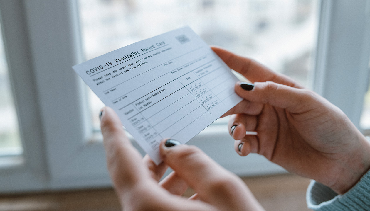 Image of a person holding their COVID-19 vaccine card