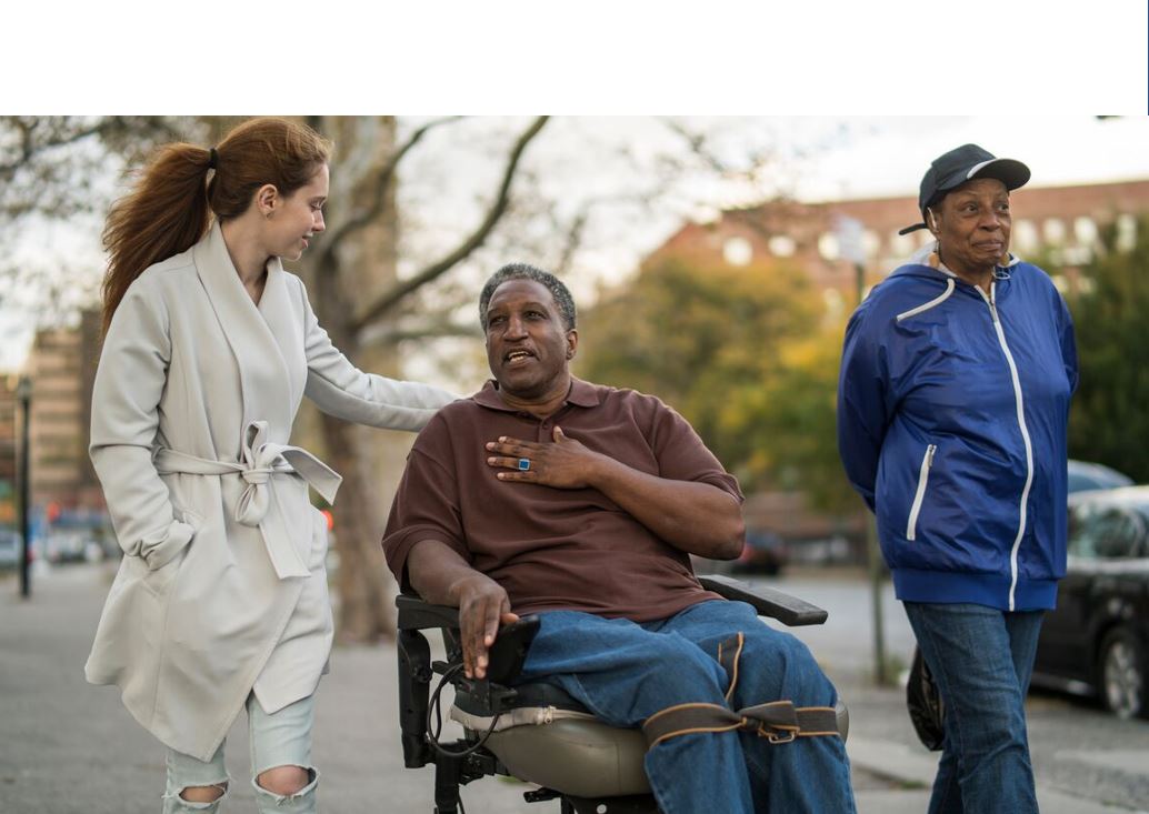 Image of a caregiver and friend and a man in his wheelchair