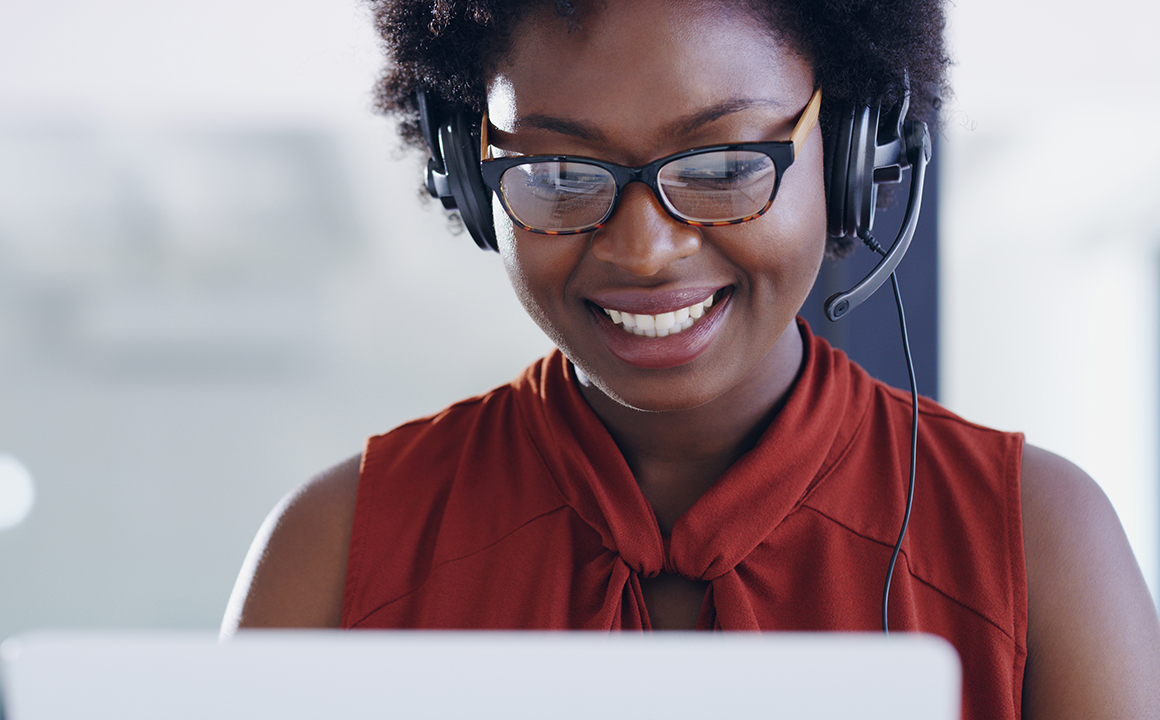 Image of a woman using a headset while on a a computer