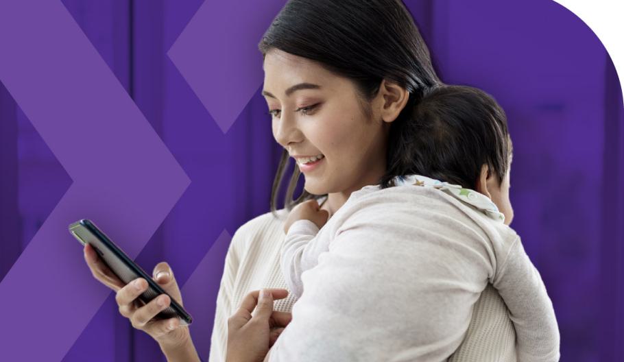 Image of a woman holding a child while looking at her mobile device