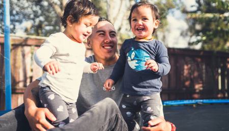Image of a father playing with his two kids