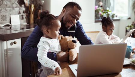 Image of a young family using a laptop during breakfast
