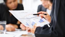 Image of a business professional looking a data on a chart. 