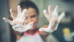 Image of a child showing her soapy hands.