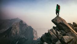 Image of a person standing at the top of a mountain