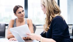 Image of a young woman receiving business mentorship advice.